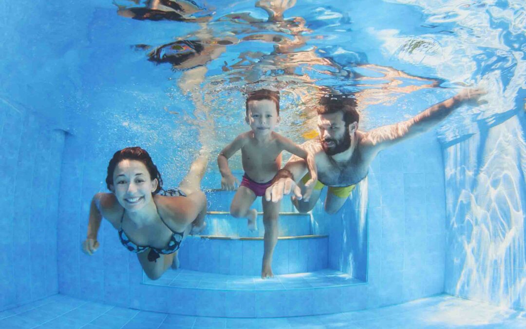 Happy family with children swimming with fun in pool
