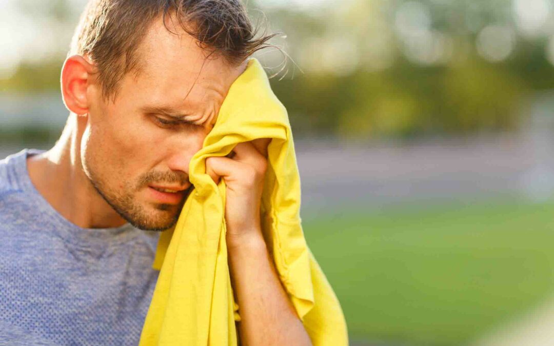 Athletic man wipes his face with yellow towel